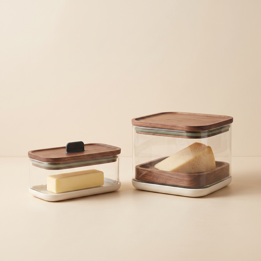 Coordinated clear cheese and butter storage keepers with warm wood accents